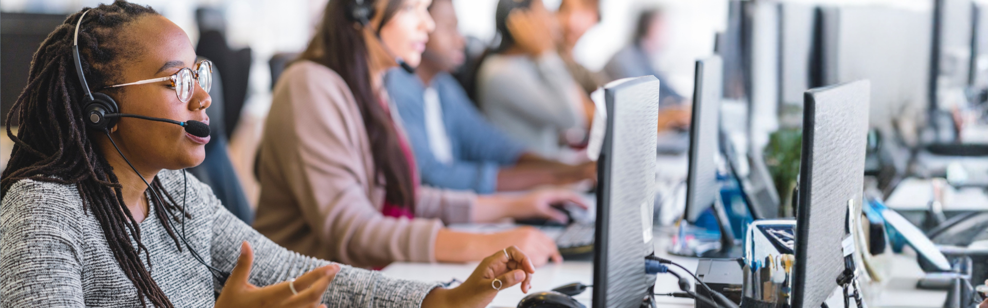 Customer contact center people with headsets using computers