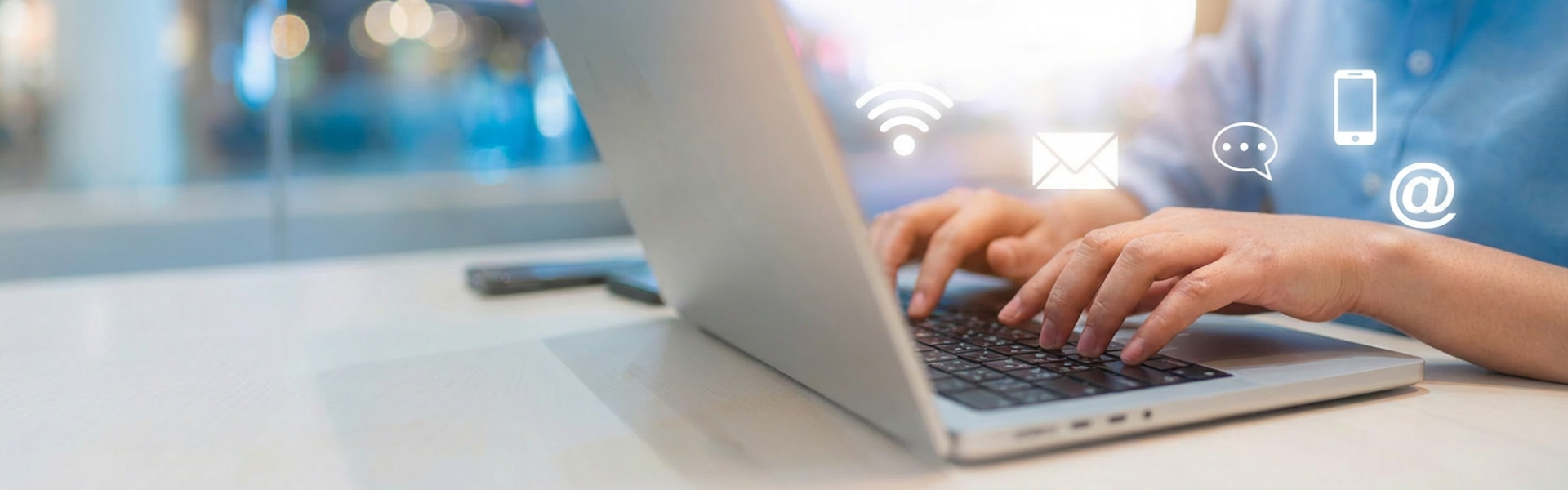 hands typing on laptop, omnichannel icon overlay